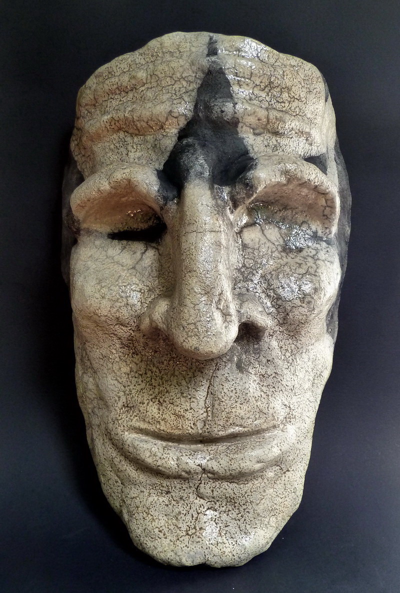 Maschera artistica in tecnica raku, caratterizzata da texture irregolari, effetti del fuoco e linee essenziali che evocano un volto archetipico.
